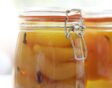 Fruit in afgesloten glazen pot met kruiden.