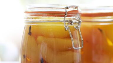 Fruit in afgesloten glazen pot met kruiden.