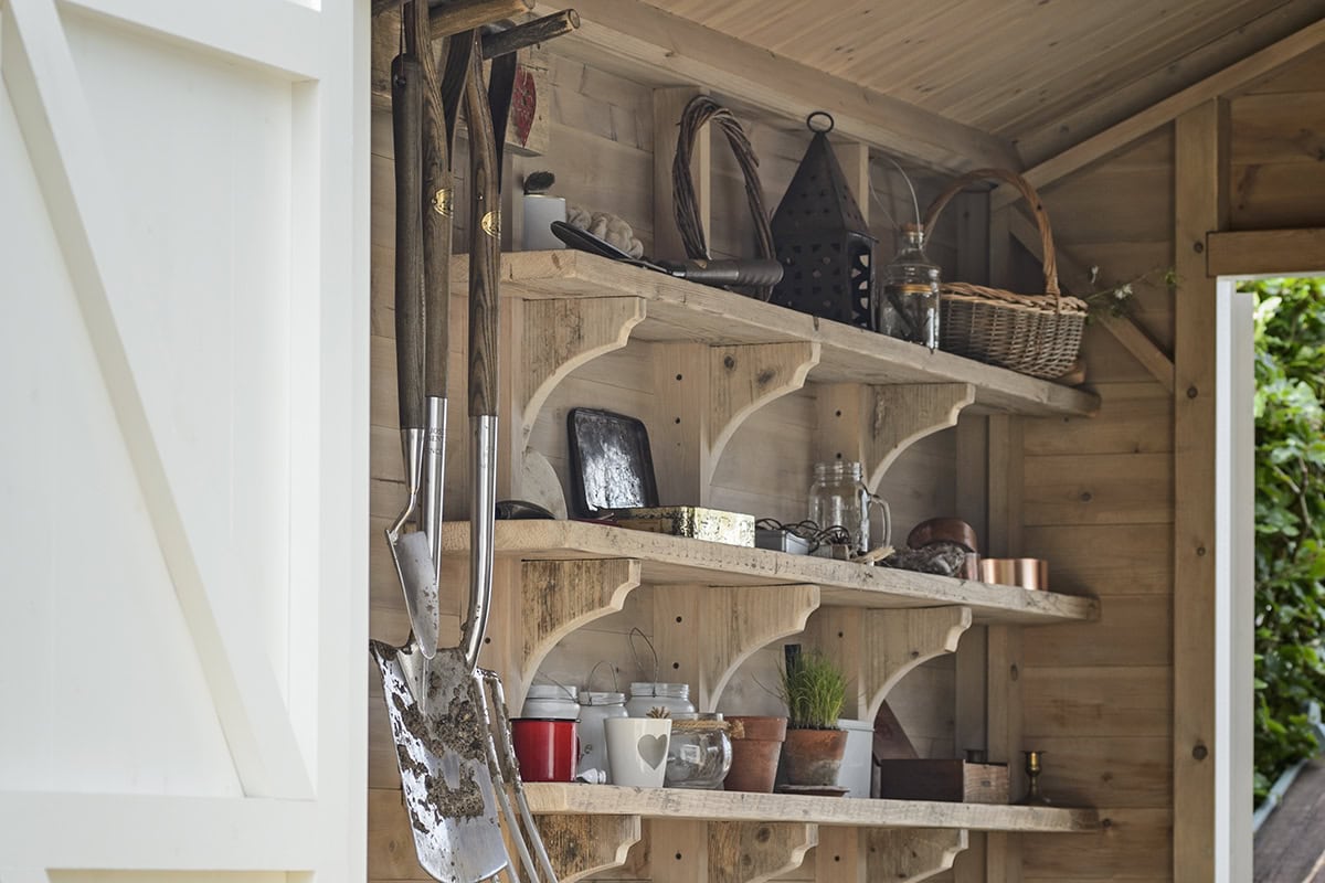 Schappen met spullen en gereedschap in een tuinhuis/schuur.