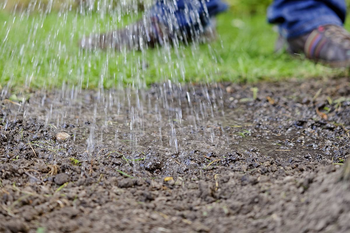 Iemand giet water over grond