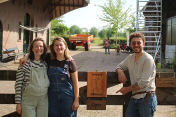 De kwekers van Kwekerij Kleikracht op staan tegen een hek aan te poseren.