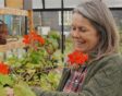 Jacqueline op de kwekerij met rode bloemen.