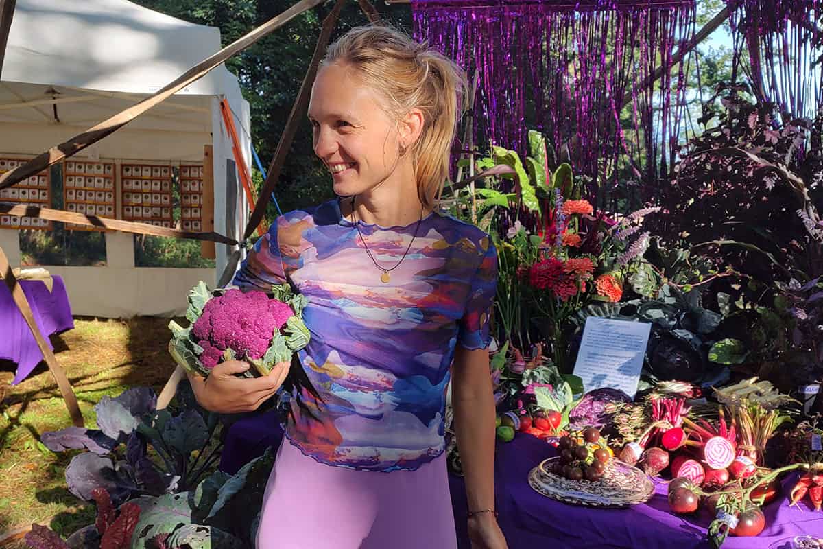 Heleen in de zon met een paarse groente in haar hand.