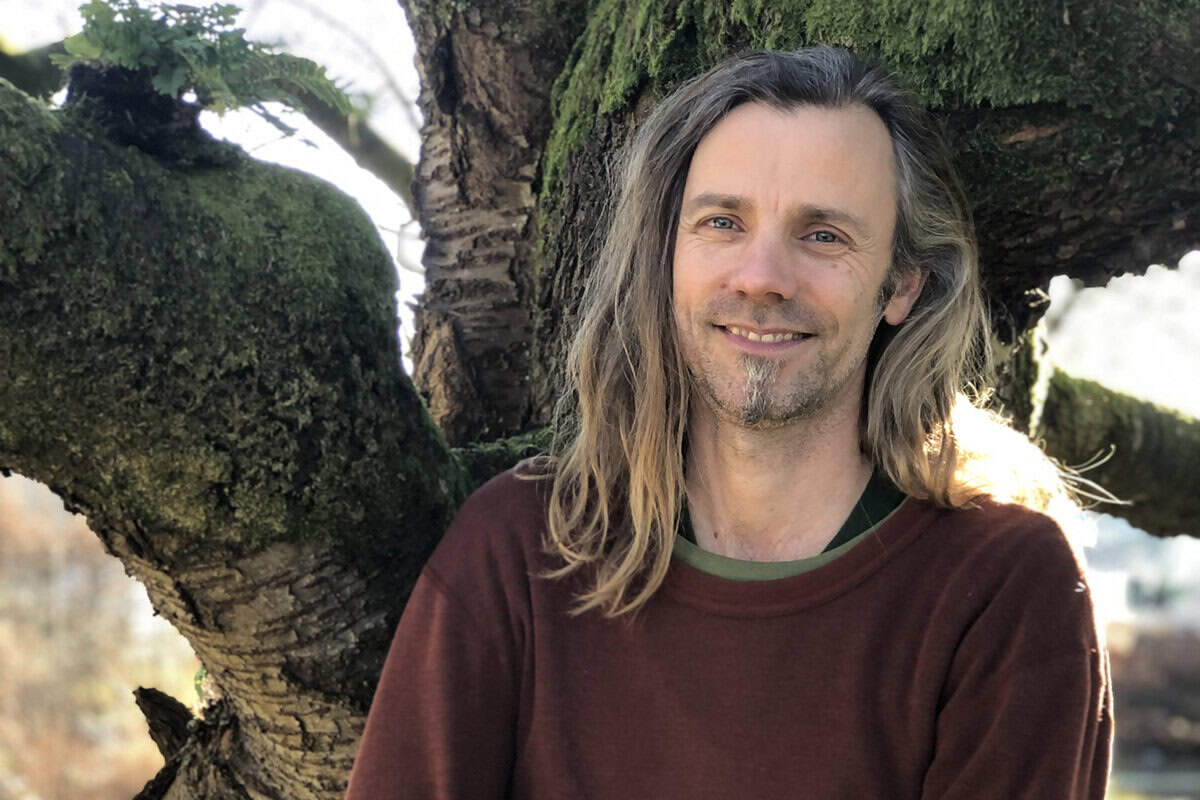 Jeroen van Mill poseert voor een boom.