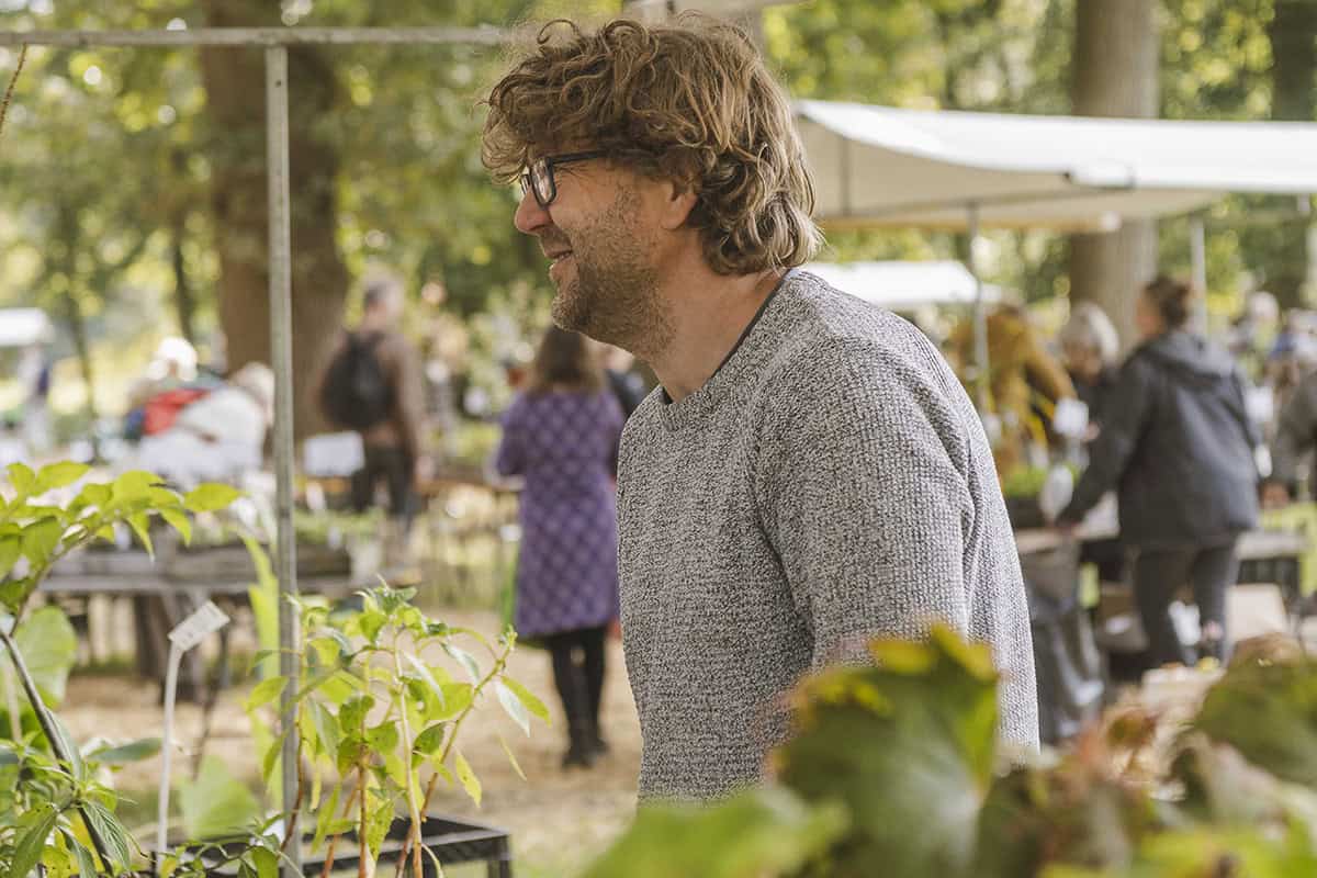 Pieter van kwekerij Pieters Planten verkoopt planten op de Ambachtelijke Plantenmarkt, achter zijn stand.