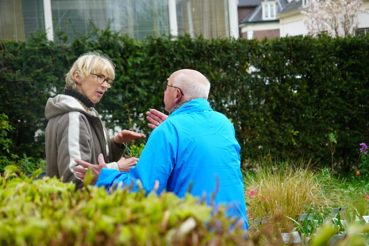 Saskia helpt een klant op de kwekerij; ze praten.