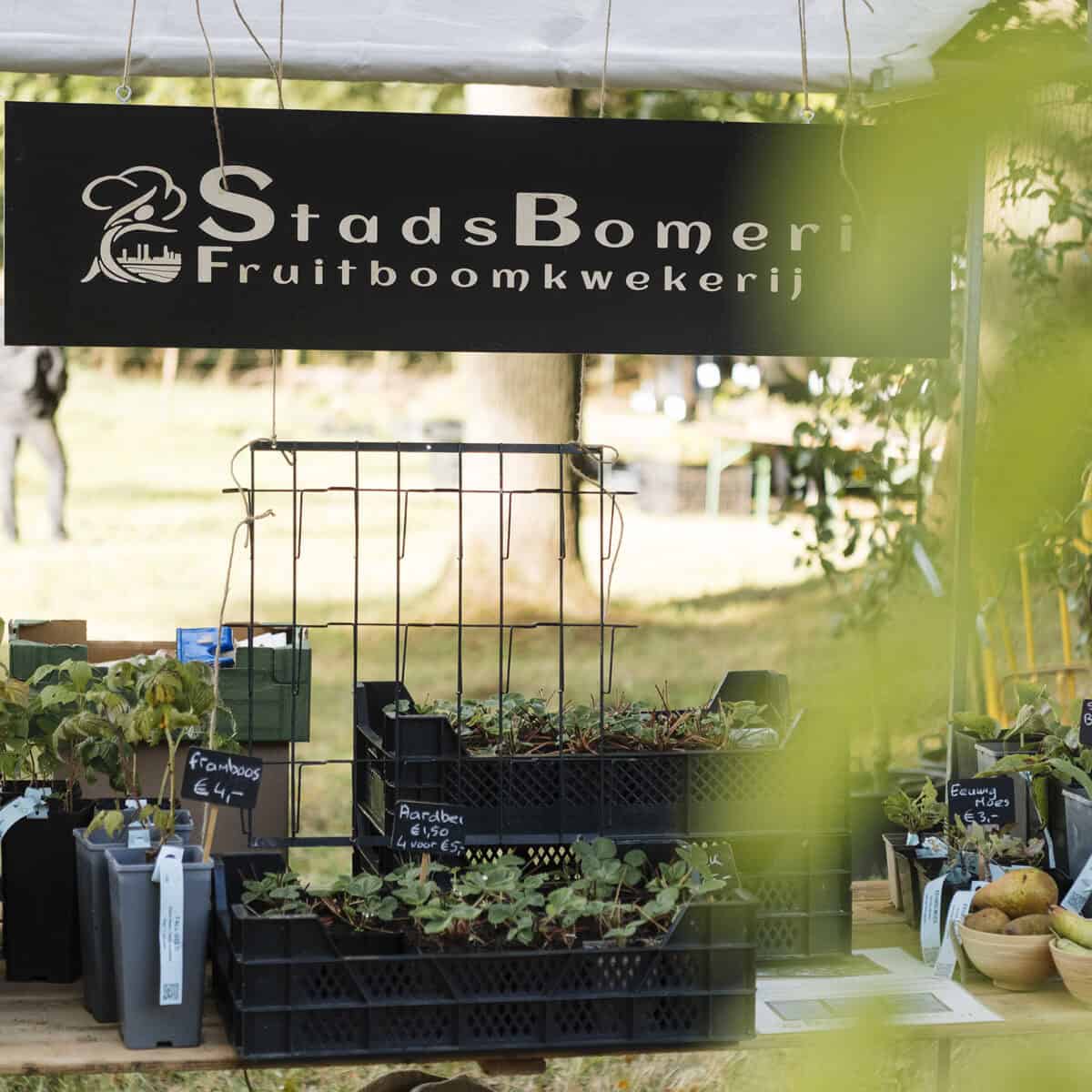 De kraam van StadsBomerij met een zwart bord op de Ambachtelijke Plantenmarkt.