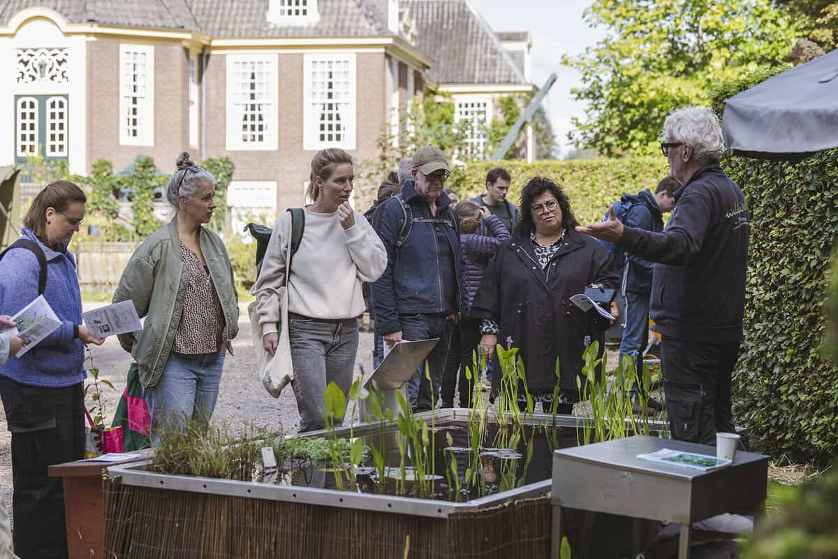 Rob vertelt op de Ambachtelijke Plantenmarkt over een vijver naast hem.