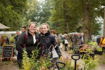 Twee zussen met hun aankopen op de ambachtelijke plantenmarkt