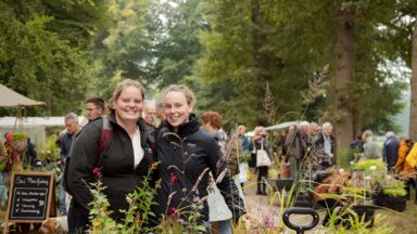 Twee zussen met hun aankopen op de ambachtelijke plantenmarkt