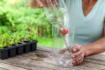 Vrouw stopt 2 helften van plastic fles in elkaar.