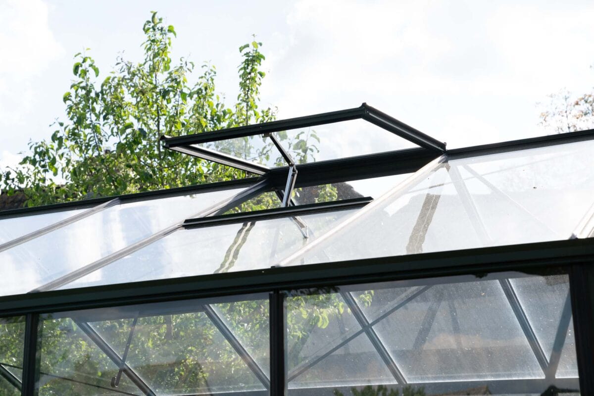 Het dak van een kas met een open raam.