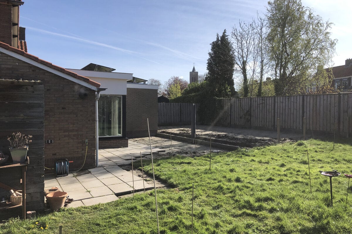 De beginsituatie voor de tuinrenovatie van Miranda: tegels en gras.