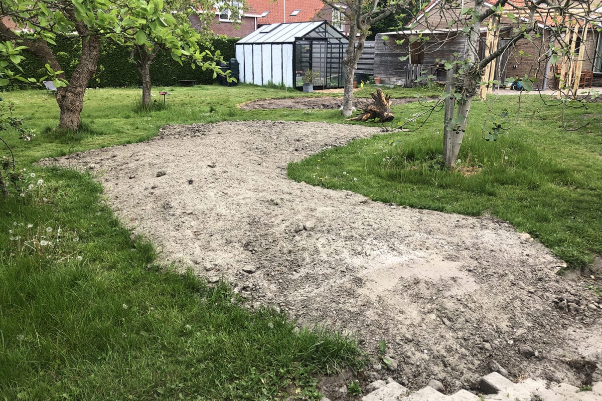 Zandheuvel in een tuin die getransformeerd wordt.