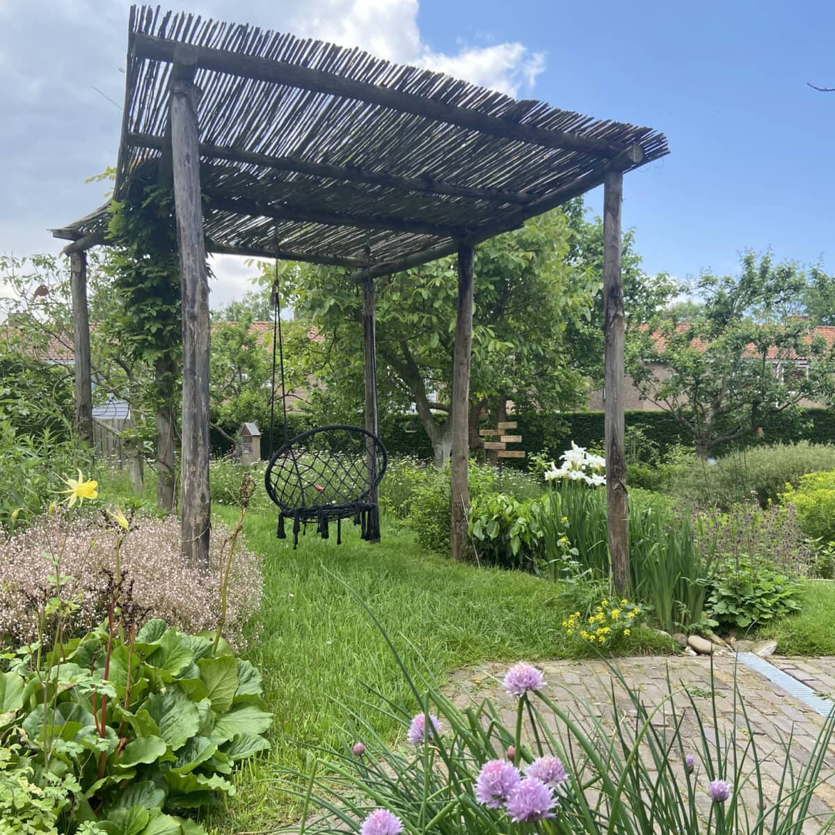 Houten pergola in de zonnige tuin van Miranda Engels