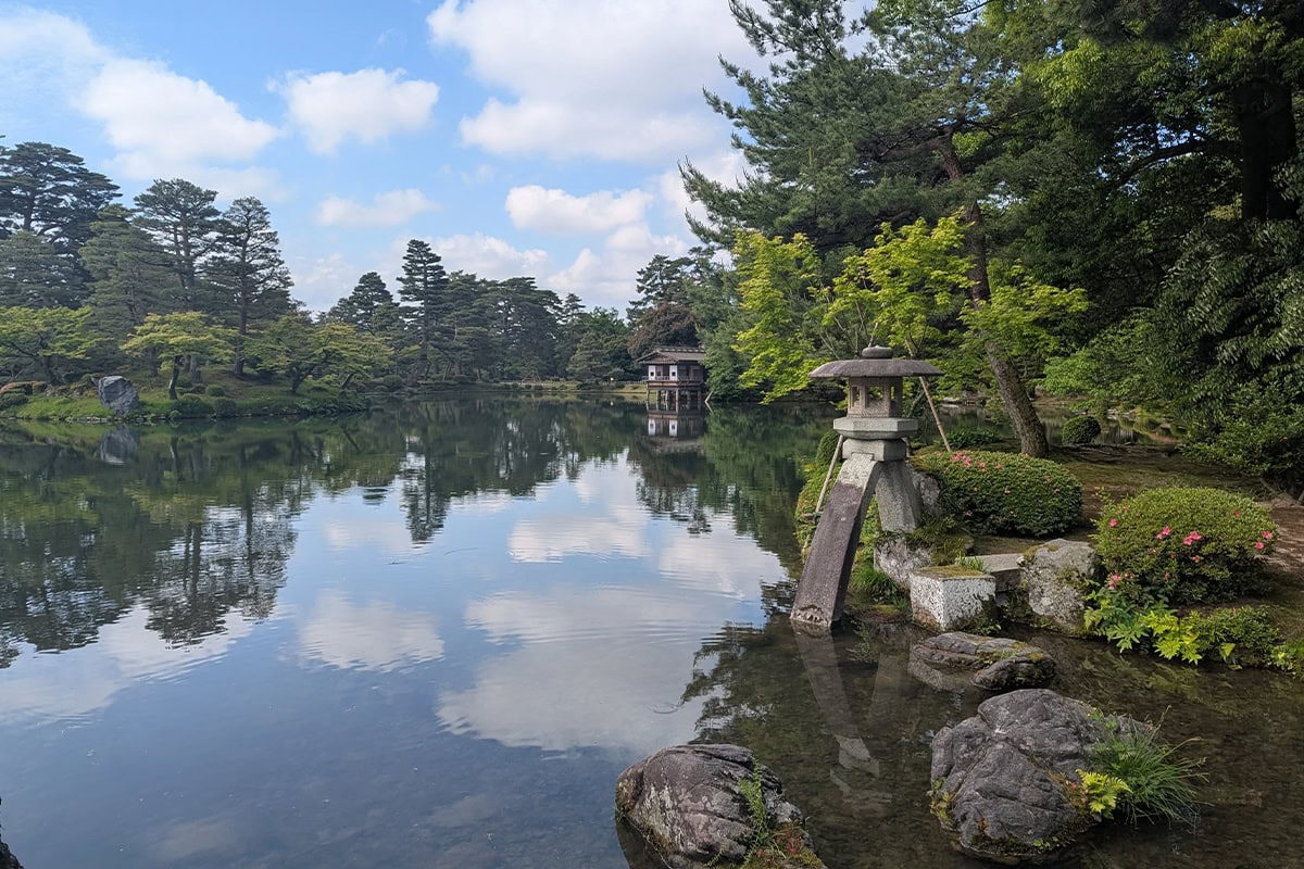 Het prachtige Kanazawa Kenrokuen met bomen, water en met mos begroeide stenen.