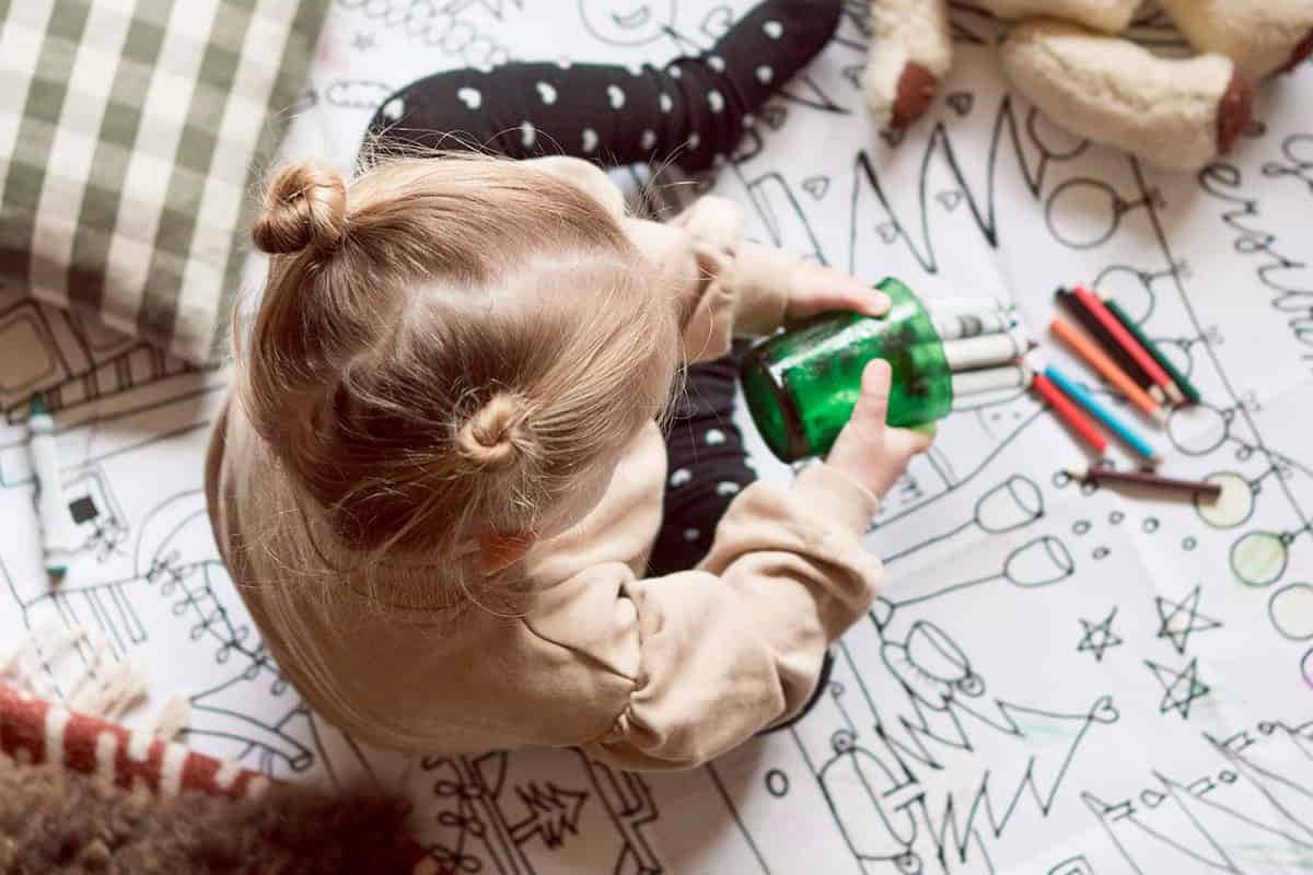 Kind met stiften en de kerstkleurplaat.