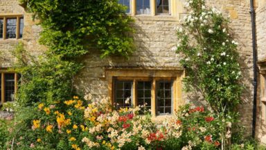 Een close-up van het landhuis omringd door bloemen bij Upton Wold.