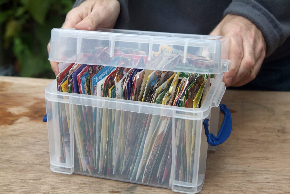 Een plastic voorraadbak gevuld met heel veel zadenzakjes.