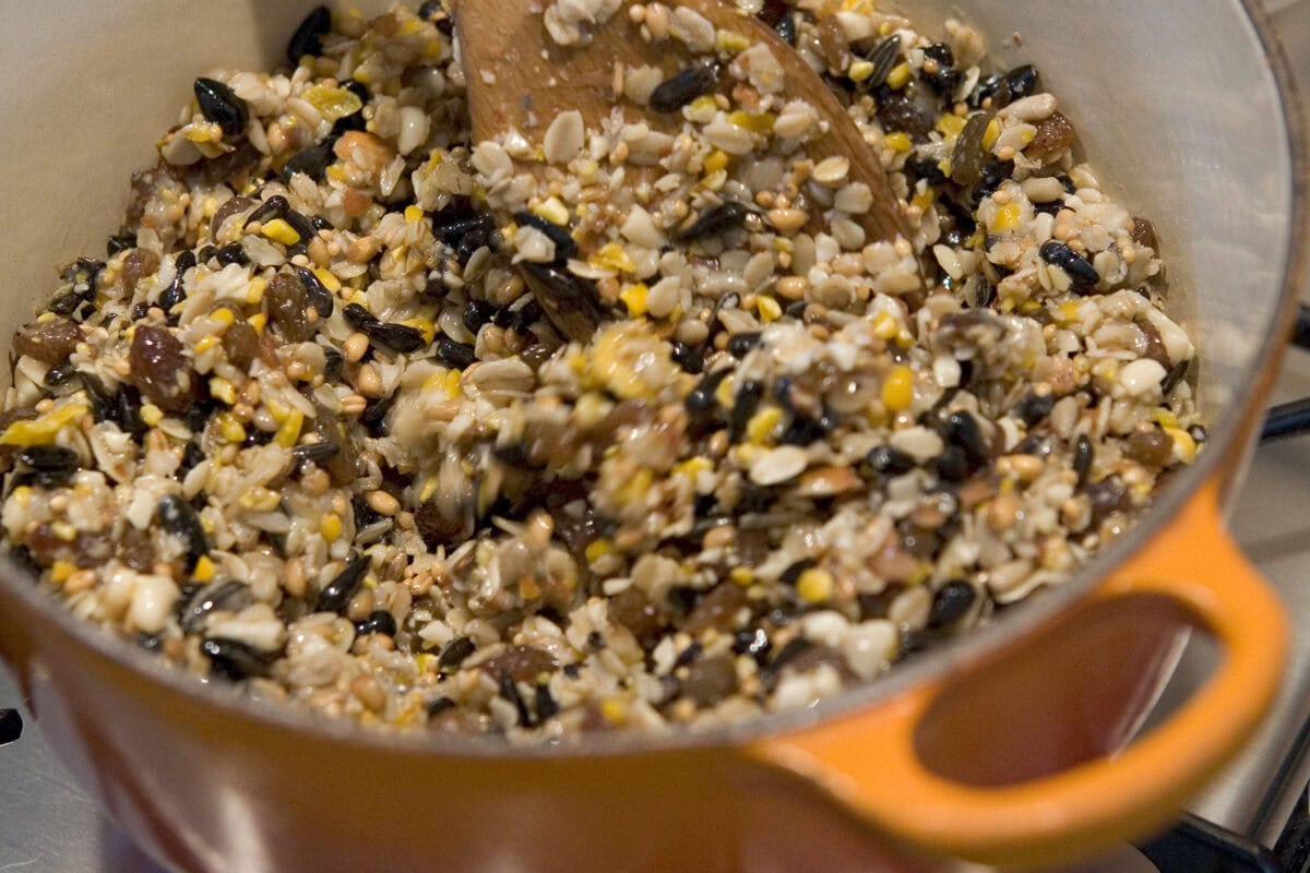 Iemand roert in een man de zaden het het vet door elkaar, voor het maken van vetbollen