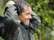 Tuinexpert Monty Don trekt zijn regenjas aan in de tuin.