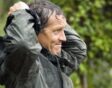 Tuinexpert Monty Don trekt zijn regenjas aan in de tuin.