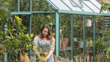 Tuinvrouw Anne staat voor haar kas