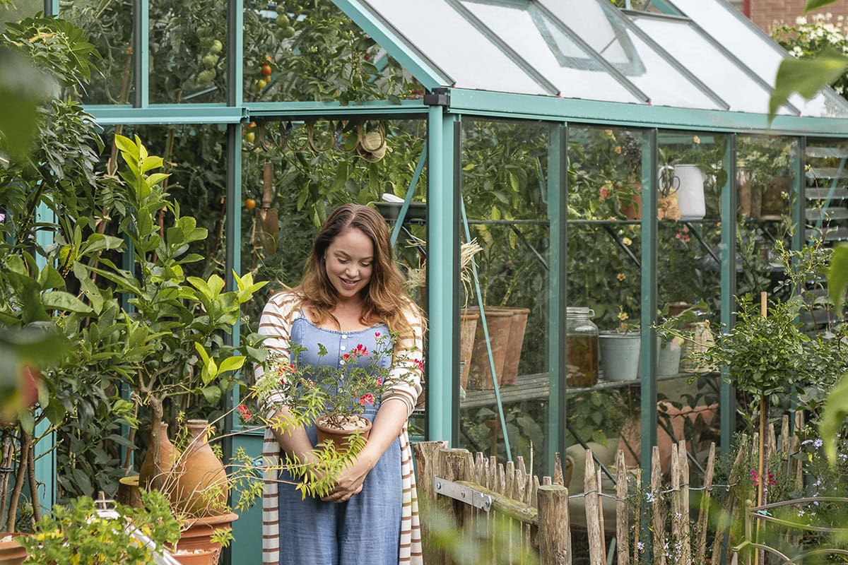 Tuinvrouw Anne staat voor haar kas