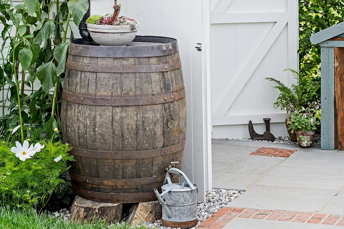 houten vat op houtblokken met kraantje en gieter