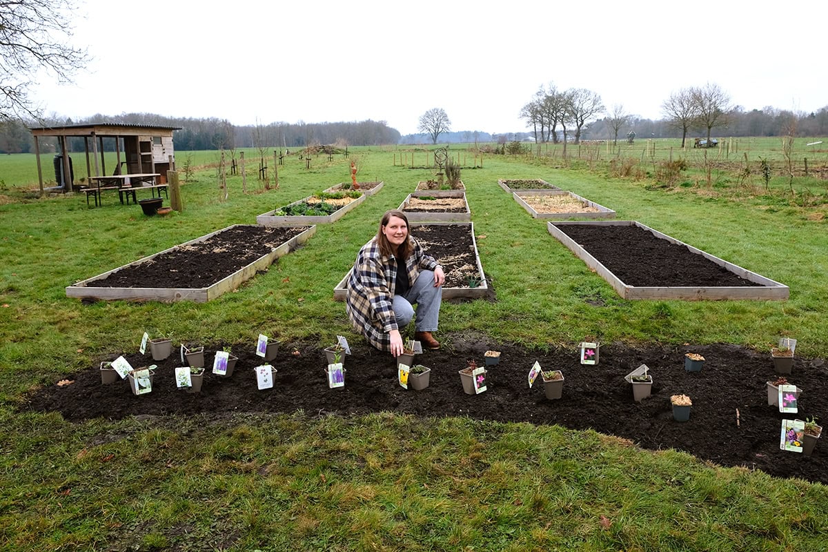 Hester bij haar nieuwe border met de planten die klaarstaan om uitgeplant te worden.
