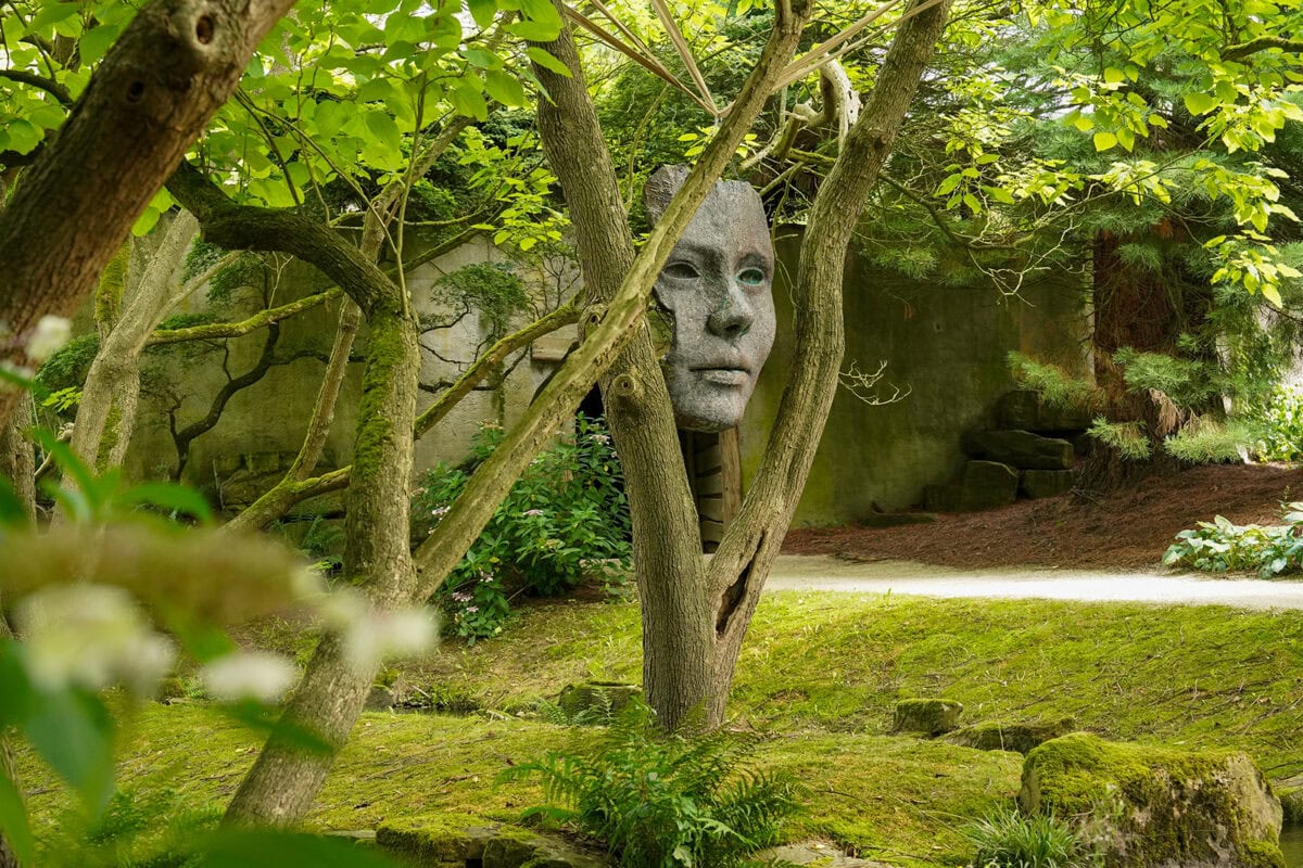 Kunstwerk van een gezicht in de tuin van Kasteeltuinen Arcen.