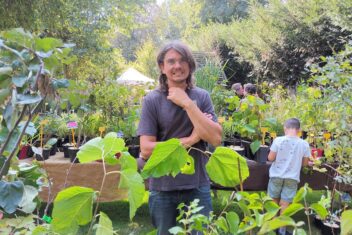 Diderik (man met bril) staat bij planten.