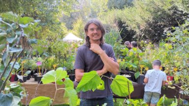Diderik (man met bril) staat bij planten.