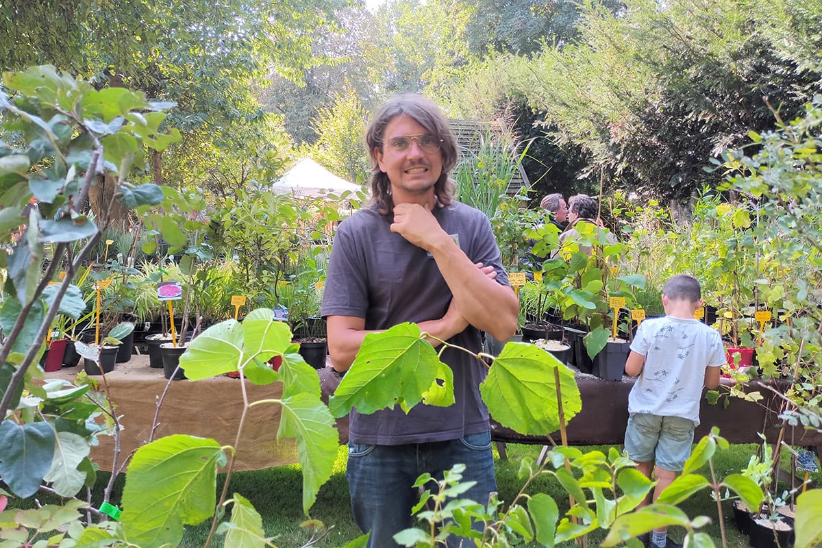 Diderik (man met bril) staat bij planten.