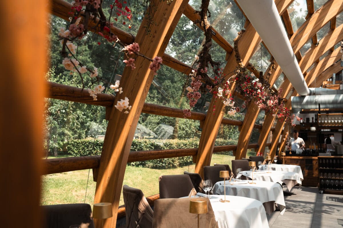 Gedekte tafels in een glazen kas bij Orangerie de Pol