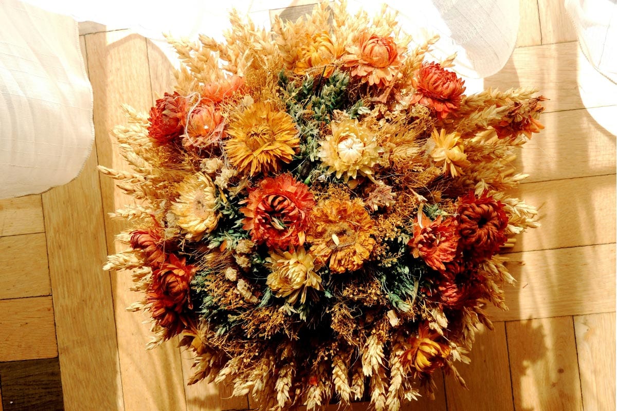 Een droogbloemenboeket met strobloemen en grassen.