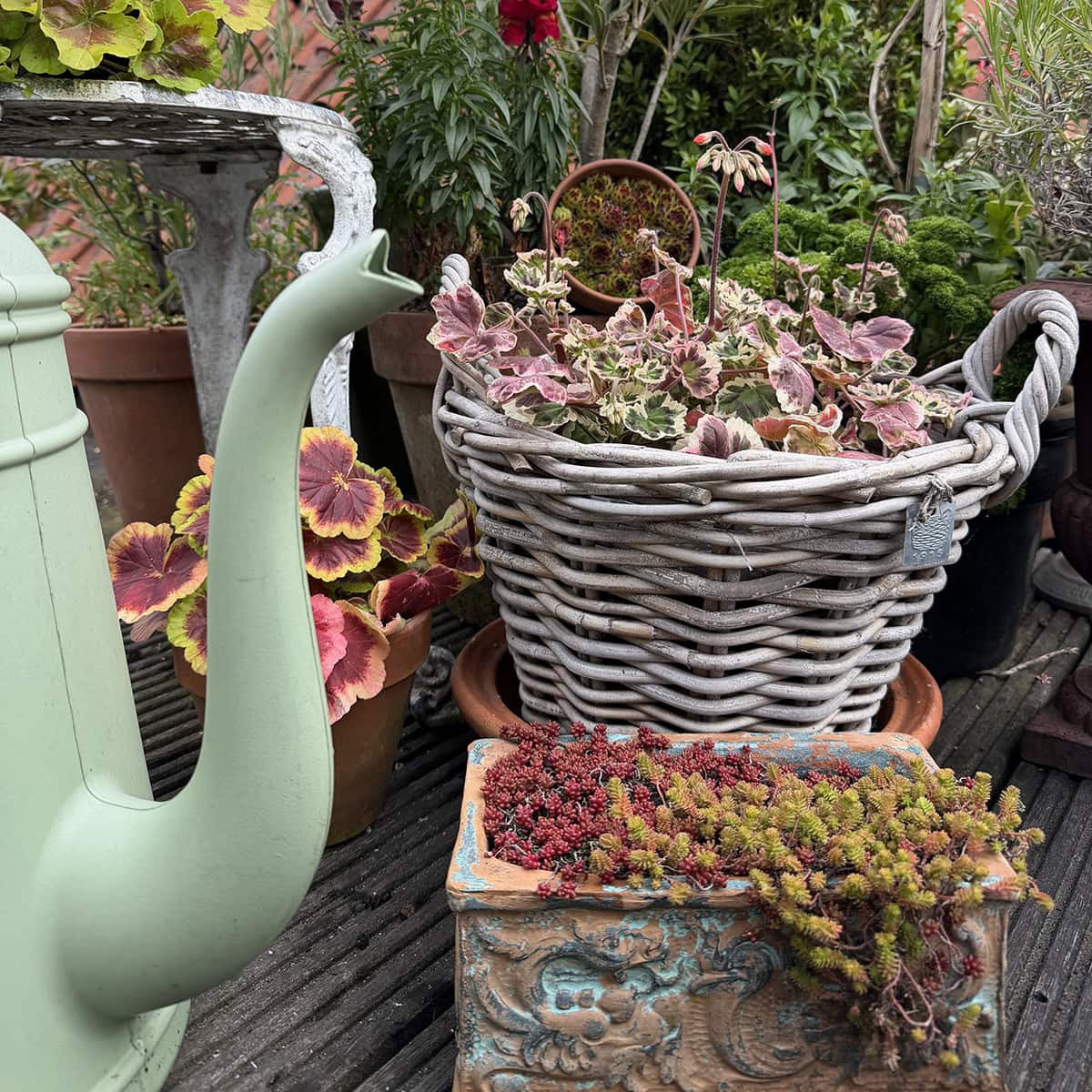 Een gieter, mand en plantenpotten.