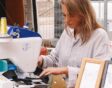 Blonde vrouw borduurt met een machine