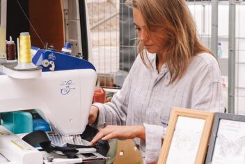 Blonde vrouw borduurt met een machine