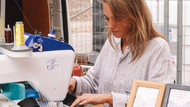 Blonde vrouw borduurt met een machine