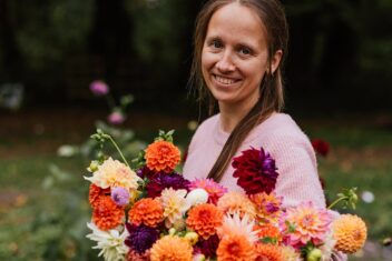Lies kijkt in de camera en heeft een bos bloemen vast.
