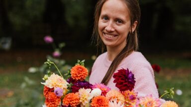 Lies kijkt in de camera en heeft een bos bloemen vast.