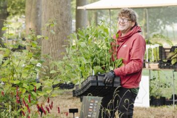 Kweker Pieter met een tray met planten in zijn handen.