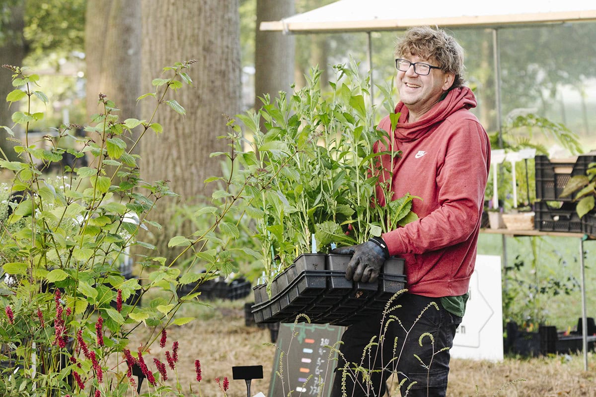 Kweker Pieter met een tray met planten in zijn handen.