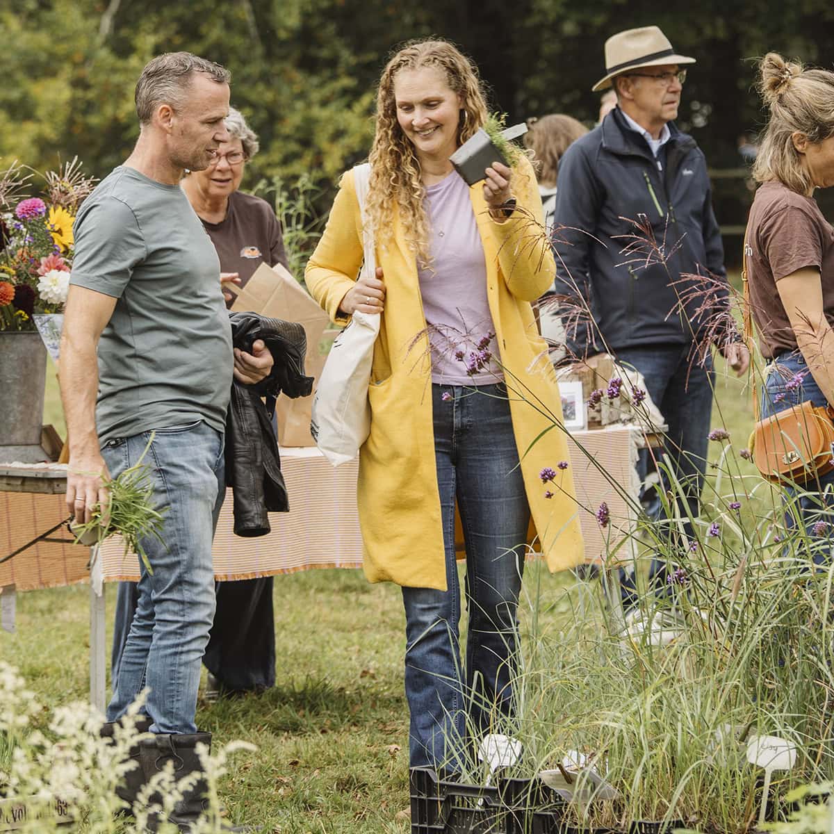 Bezoekers tussen de planten met hun aankopen.