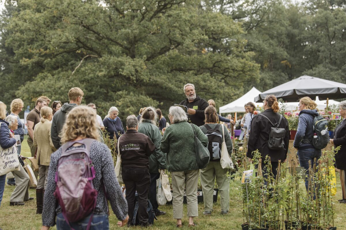 Hans van De Bierkreek torent uit tussen mensen die luisteren naar zijn lezing op de plantenmarkt.