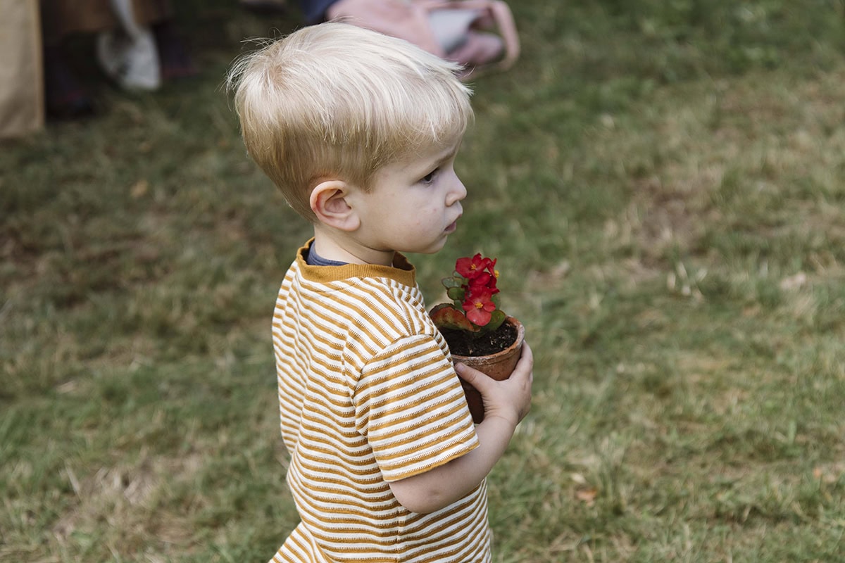 Jong kind met plantje in zijn hand.