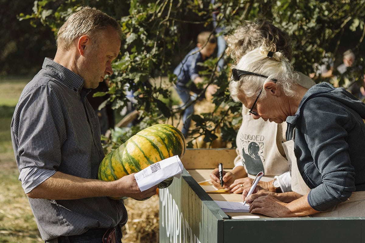 Man levert pompoen in bij vrouw op de Ambachtelijke Plantenmarkt