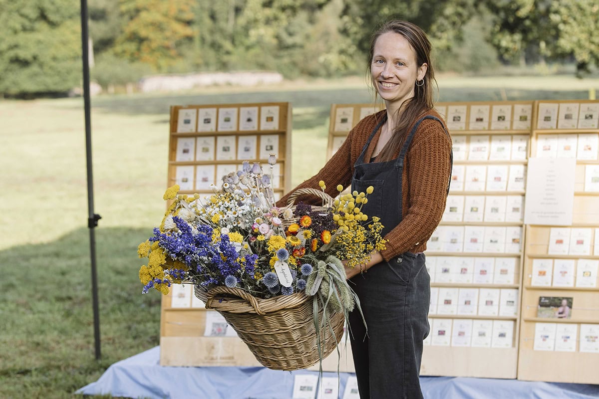 Kweker Lies Couckuyt met mand bloemen op de Ambachtelijke Plantenmarkt,