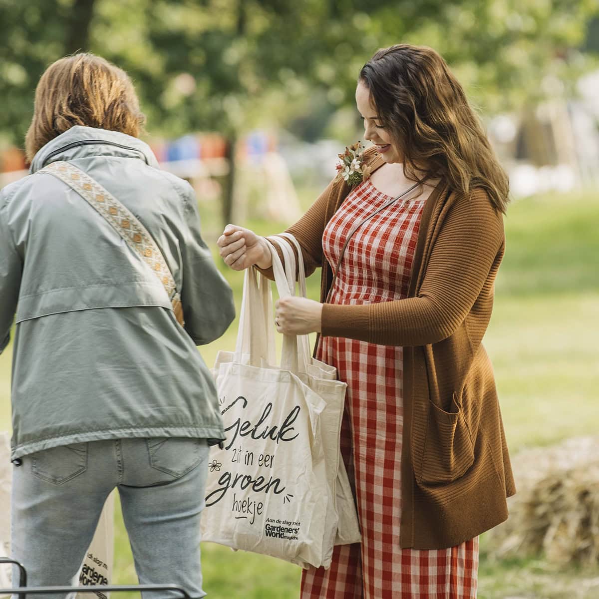 Anne deelt goodiebags uit op de plantenmarkt.